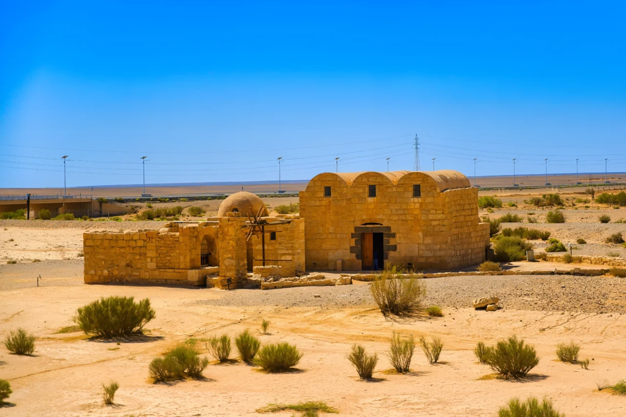 Construction en pierre ocre aux dômes arrondis dans un paysage désertique clairsemé